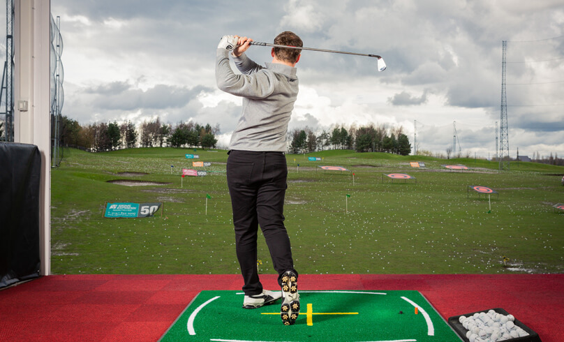 Man practising at the golf driving range