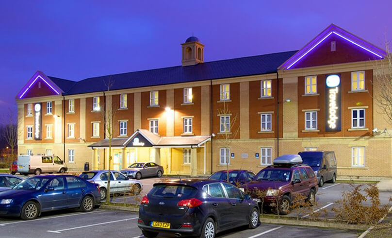 Outside of the Travelodge at night.